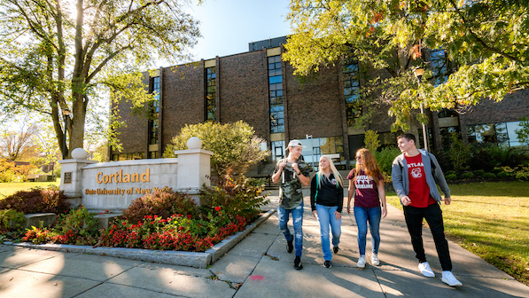 Students walking in front of the Miller Building and SUNY Cortland sign